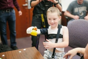 Alex Pring first tries his new bionic arm. Photo Credit: KT Crabb Photography  